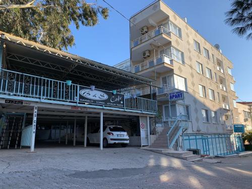 a white car parked in front of a building at Beyaz Saray Apart Otel in Ayvalık