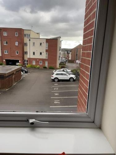 a window with a car parked in a parking lot at Ideal Flat for Work/Holidays/Fun in Etruria