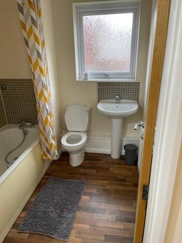 a bathroom with a toilet and a sink and a window at Ideal Flat for Work/Holidays/Fun in Etruria