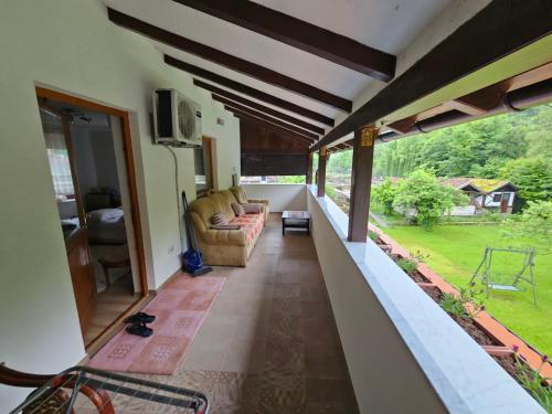 a living room with a couch and a balcony at Apartman Slapovi in Krupa na Vrbasu
