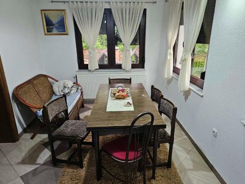 uma mesa de jantar e cadeiras com um cão a dormir nela em Apartman Slapovi em Krupa na Vrbasu