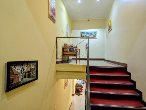 a staircase in a house with red carpeting and a stair case at Mvuli Hotels Arusha in Arusha