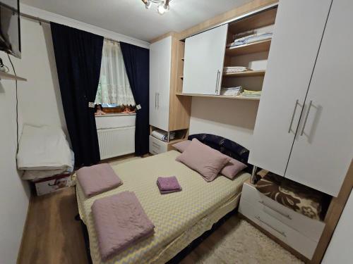 um pequeno quarto com uma cama e uma janela em Apartman Slapovi em Krupa na Vrbasu