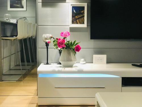a vase with pink flowers on top of a table at SLAVNA - Luxe & Wine by the Fortress in Belgrade