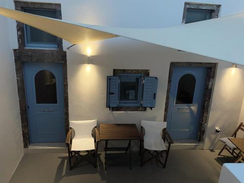 a dining room with a table and chairs and a tv at Arco Bianco Suites in Akrotiri