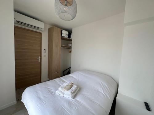 une chambre avec un lit blanc avec des serviettes dessus dans l'établissement Superbe T2 en dernier étage, à Antibes