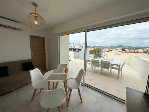 un salon avec une table et des chaises et un balcon dans l'établissement Superbe T2 en dernier étage, à Antibes