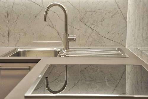 a kitchen sink with a faucet on a counter at Apartments Bagar in Portorož