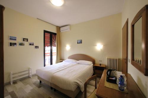 een slaapkamer met een bed en een tafel. bij Hotel Primavera in Peschiera del Garda