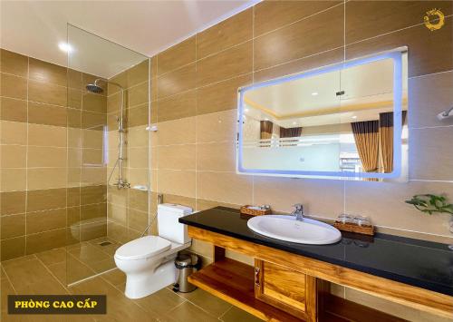 a bathroom with a sink and a toilet and a mirror at Rồng Vàng Resort in Tri Tôn