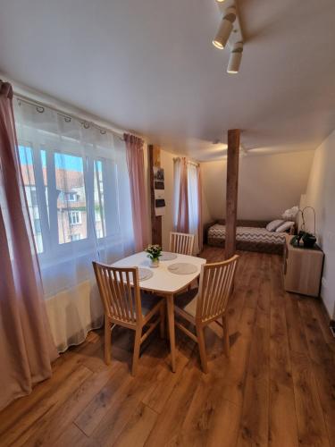 ein Esszimmer mit einem Tisch und Stühlen sowie ein Schlafzimmer in der Unterkunft KANTO - self check in in Klaipėda