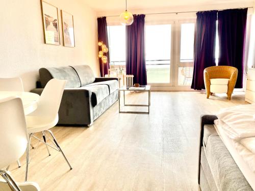 ein Wohnzimmer mit einem Bett, einem Tisch und Stühlen in der Unterkunft Studio mit Panorama-Meerblick und direkter Strandlage in Scharbeutz in Scharbeutz