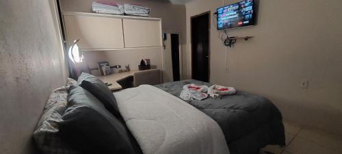 ein Wohnzimmer mit einem Sofa und einem TV in der Unterkunft Casa Canto do Farol in Navegantes