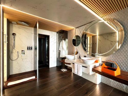 a bathroom with two sinks and a large mirror at Makanda by The Sea Hotel Adults Only in Manuel Antonio