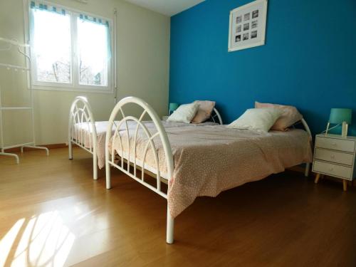 een slaapkamer met een wit bed en een blauwe muur bij La maison d'audignon in Audignon