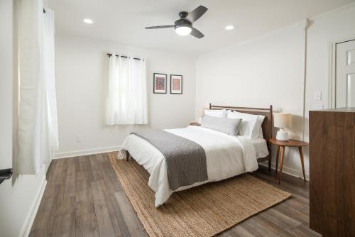 a white bedroom with a bed and a ceiling fan at The Victorian Inn Blowing Rock in Blowing Rock