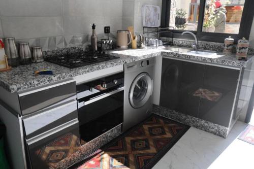 Il comprend une cuisine équipée d'une cuisinière et d'un lave-linge. dans l'établissement Appartement meublé et bien situé, à Meknès