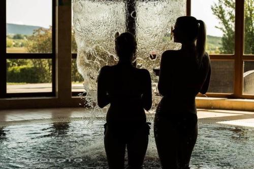 two women standing in front of a fountain at Hétkúti Wellness Hotel in Mór