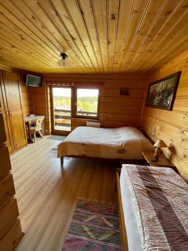 a bedroom with two beds in a wooden cabin at Agroturystyka Pod Gronikami pokoje in Danielky
