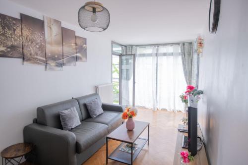 a living room with a couch and a table at Excellent Apartment for Familly in Clichy