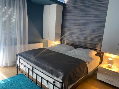 a bedroom with a large bed with a large window at Terra Toscana Apartman in Sárvár