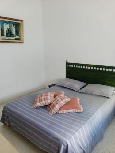 ein Bett mit zwei Kissen darüber in der Unterkunft Appartement propre près de l'ENIS in Sfax