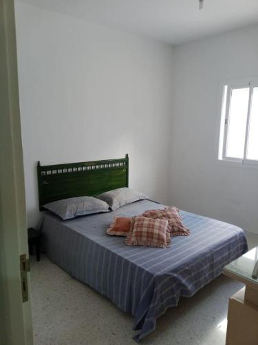 - un lit avec 2 oreillers dans une chambre dans l'établissement Appartement propre près de l'ENIS, à Sfax
