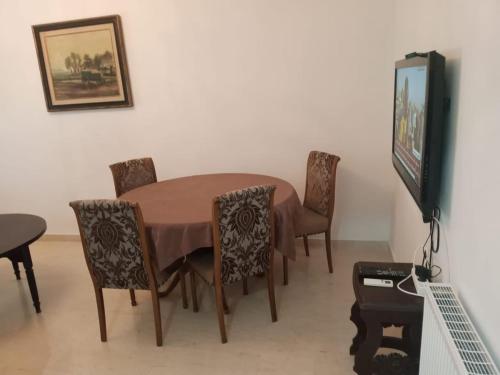 jadalnia ze stołem i krzesłami oraz telewizorem w obiekcie Appartement propre près de l'ENIS w mieście Safakis