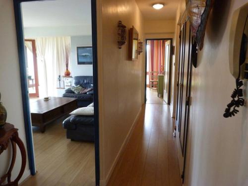 einen Flur, der zu einem Wohnzimmer mit einem Spiegel führt in der Unterkunft Appartement spacieux à deux pas du centre in Ciboure