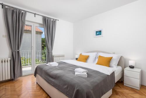 Un dormitorio con una cama grande y una ventana grande. en Garden Home Flora, en Rijeka