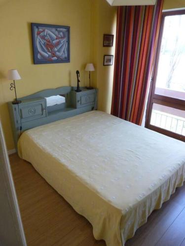 Schlafzimmer mit einem Bett und einem Fenster in der Unterkunft Appartement spacieux à deux pas du centre in Ciboure