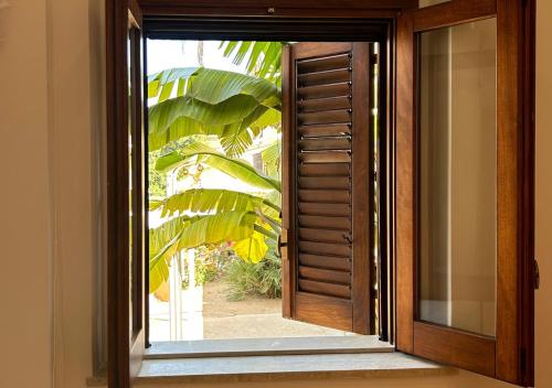 a wooden door with a window and a plant at A' BITTA in Favignana