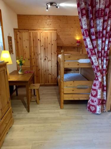 Zimmer mit einer Holzhütte mit einem Schreibtisch und einem Bett in der Unterkunft L'appartement LES BOSSONS en lisière de forêt dans le chalet Génépi in Arêches