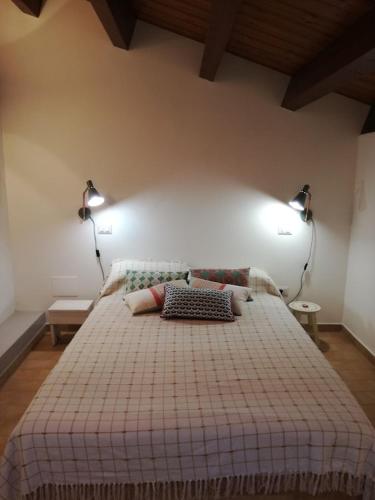 een slaapkamer met een bed met twee lampjes aan de muur bij A Corner of Paradise in Mystical Umbria with private pool in Cannara