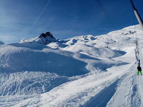 a person riding a ski lift on a snow covered mountain at L'appartement LES BOSSONS en lisière de forêt dans le chalet Génépi in Arêches