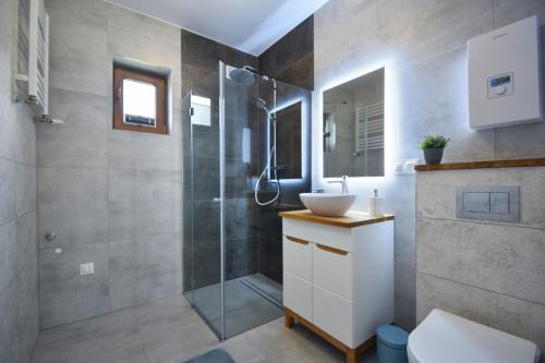 W łazience znajduje się prysznic i umywalka. w obiekcie Domki Lilia Sarbinowo w Sarbinowie