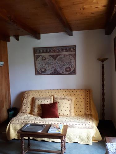 a couch in a room with a table and a picture on the wall at La maison de Juliette En haut in Lascabanes