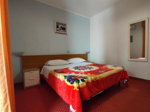 a bedroom with a bed with a red carpet at Hotel Sorriso in Sanremo