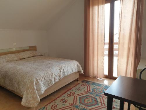 een slaapkamer met een bed, een tafel en een raam bij Casa Maria in Negreşti-Oaş