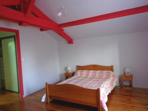 Schlafzimmer mit einem Bett und einer Holzbank in der Unterkunft Gite arriou du bruca in Sort-en-Chalosse