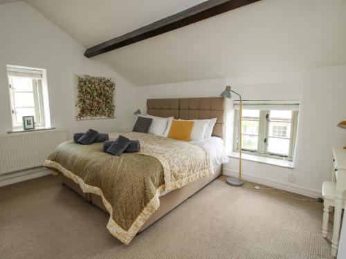 a bedroom with a large bed and two windows at Rectory Cottage in Oswestry