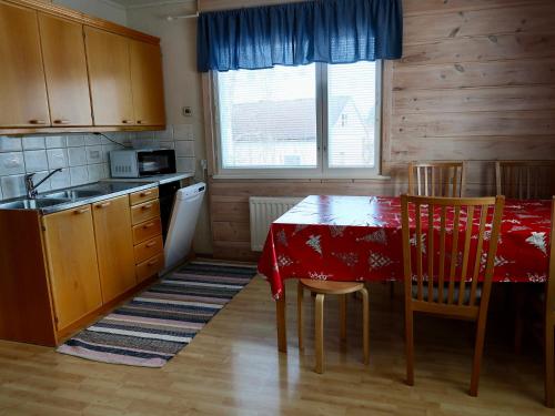eine Küche mit einem Tisch mit Stühlen und einem roten Tischtuch in der Unterkunft SportHome in Rovaniemi
