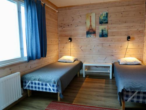 Duas camas num quarto com paredes de madeira em SportHome em Rovaniemi