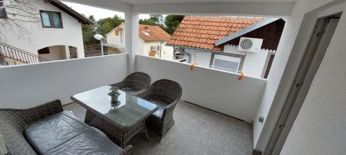 balcón con mesa y sillas en Sydney Apartment, en Bilice