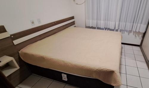 um pequeno quarto com uma cama num quarto em Descanso a 100m do Mar em Itapema
