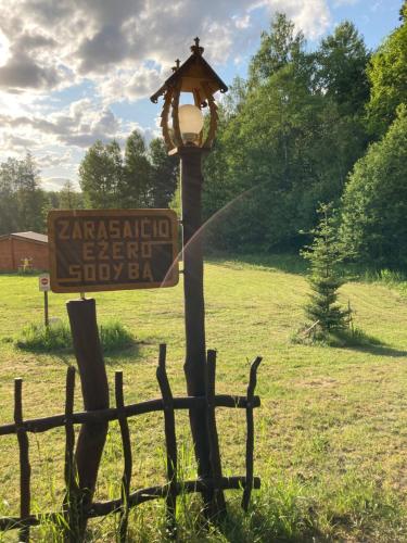a street light next to a sign in a field at Zarasaičio ežero sodyba in Magučiai