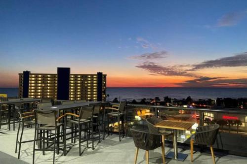 a rooftop bar with chairs and tables and the ocean at Cambria Hotel St Petersburg-Madeira Beach Marina in St Pete Beach