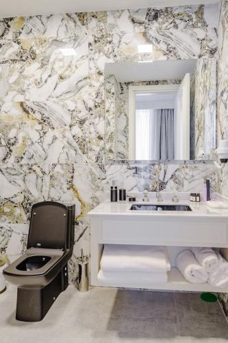 a bathroom with a white sink and a mirror at Blue Sea Karpasia Hotel in Rizokarpaso