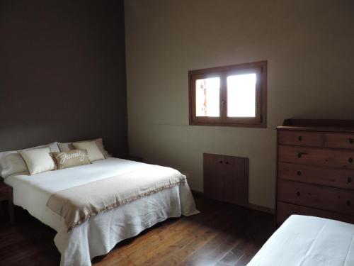 1 dormitorio con 2 camas, vestidor y ventana en Masia Bufulà, en Vallcebre