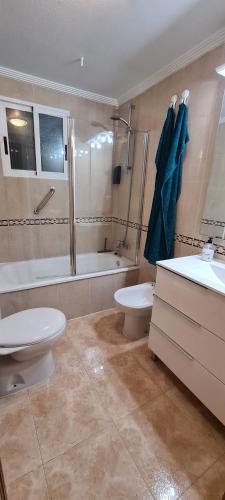 La salle de bains est pourvue de toilettes, d'une baignoire et d'un lavabo. dans l'établissement City Comfort, Your Torrevieja Retreat, à Torrevieja